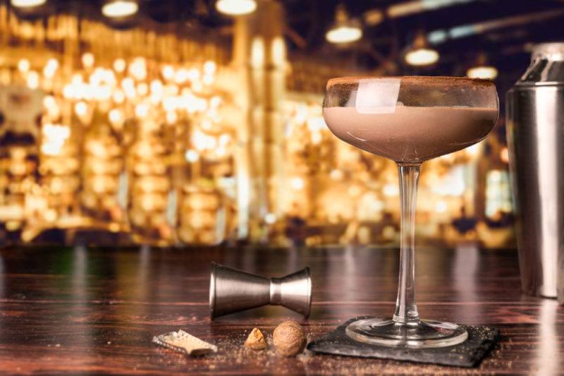 A brandy Alexander cocktail in front of a bar