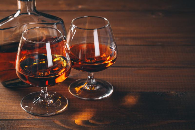 Two glasses and a decanter containing cognac or bourbon