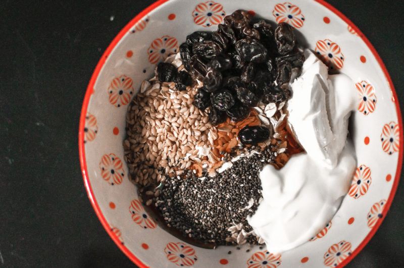 A breakfast bowl with dried fruit, yogurt and chia seeds