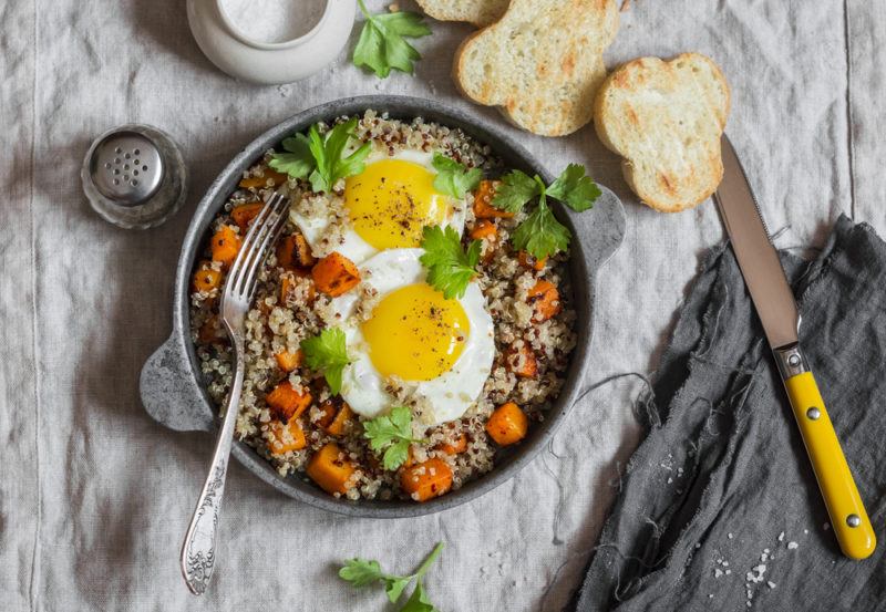 A breakfast bowl with quinoa, eggs. and veggies