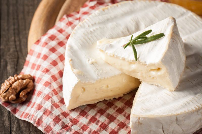 Brie with a slice cut out of it on a plate