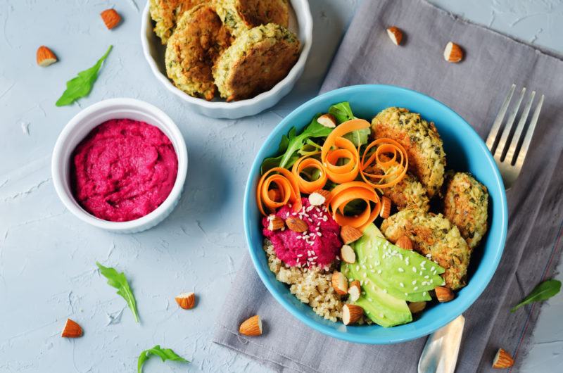 A blue bowl with falafel and beetroot hummus