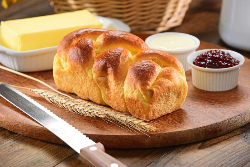 A loaf of brioche bread with spreads on a table