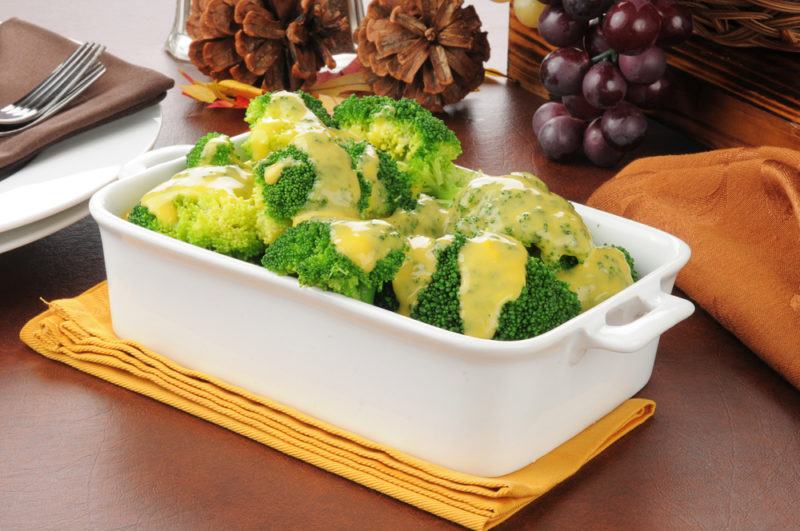 Broccoli with cheese sauce in a white dish