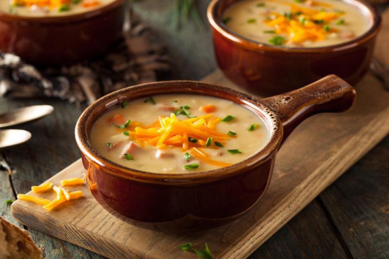 Three brown dishes containing beer cheese soup