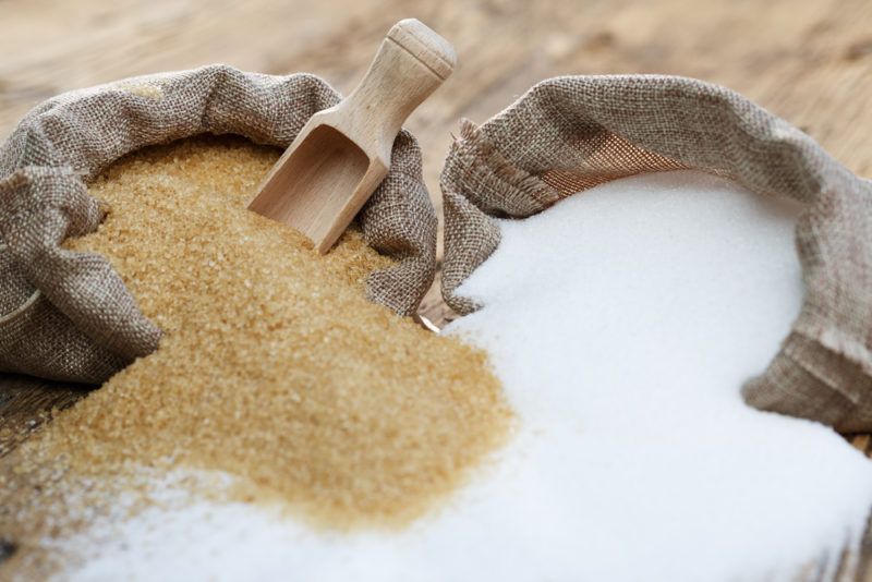 A cloth bag of brown sugar and one of white sugar