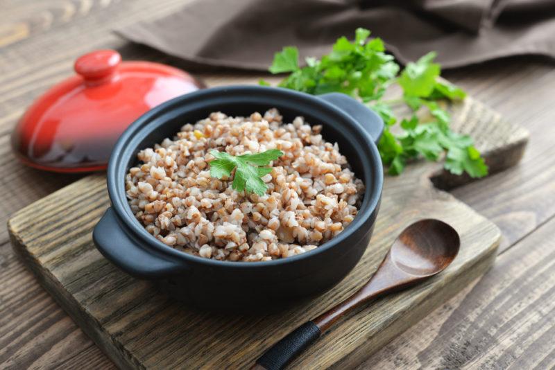 A cast iron pot containing cooked buckwheat