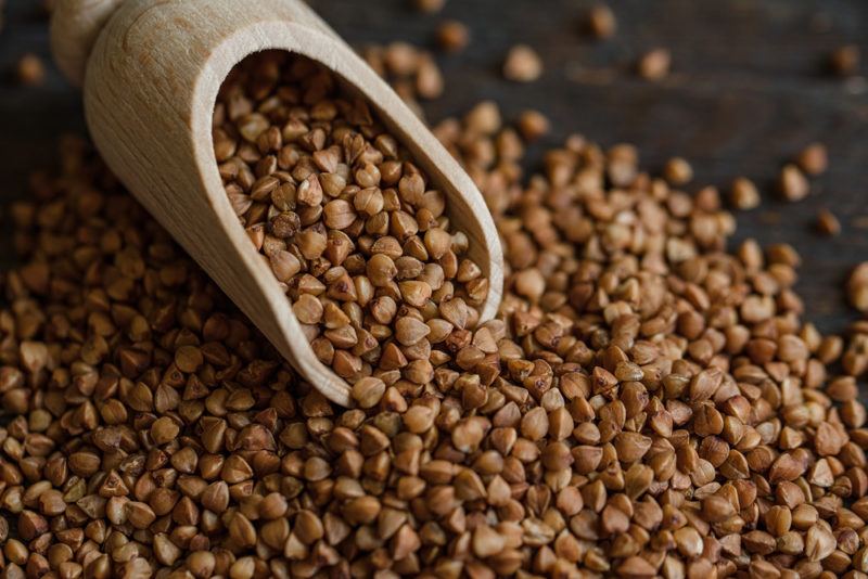 A collection of hemp seeds with a wooden spoon