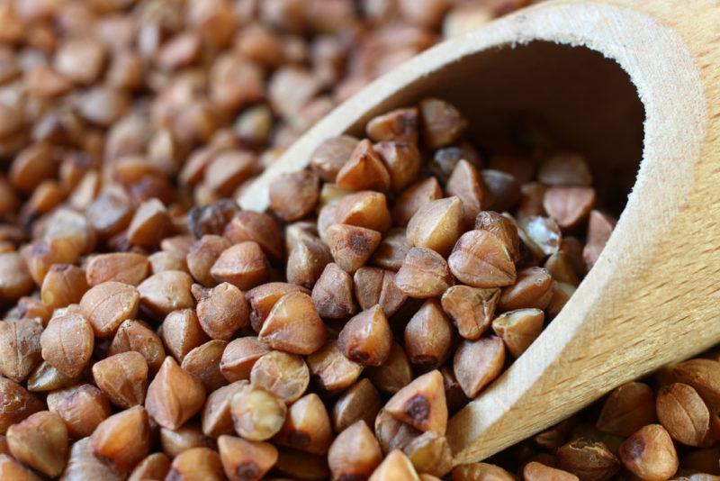 A wooden spoon full of buckwheat