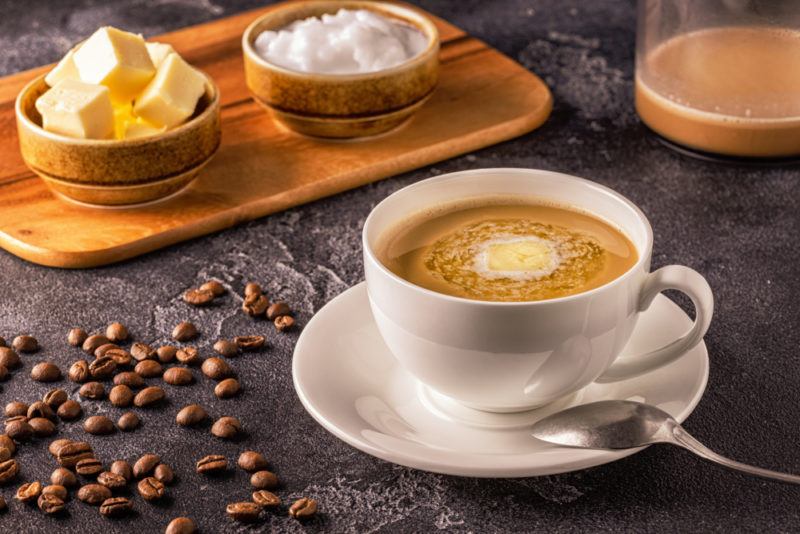 A dark table with coffee, butter, and coconut oil