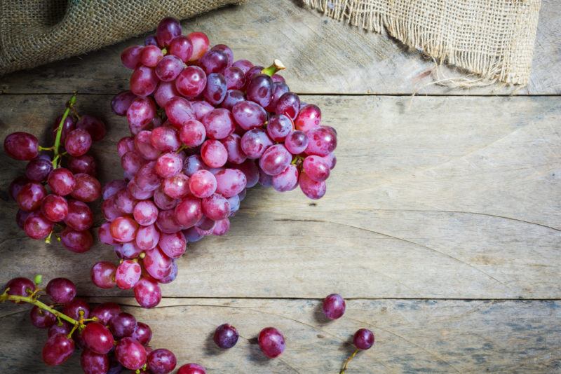 Bunches of red grapes on a wooden table