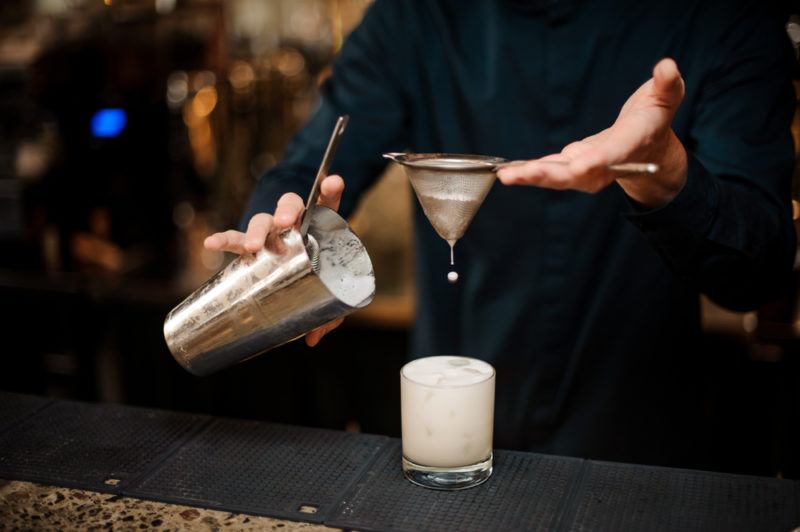 A bushwacker cocktail being strained into a glass