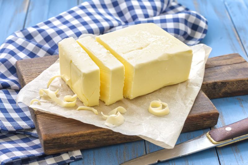 A block of butter sliced on a wooden board