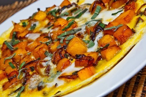 A white plate with a butternut squash and caramelized onion omelet