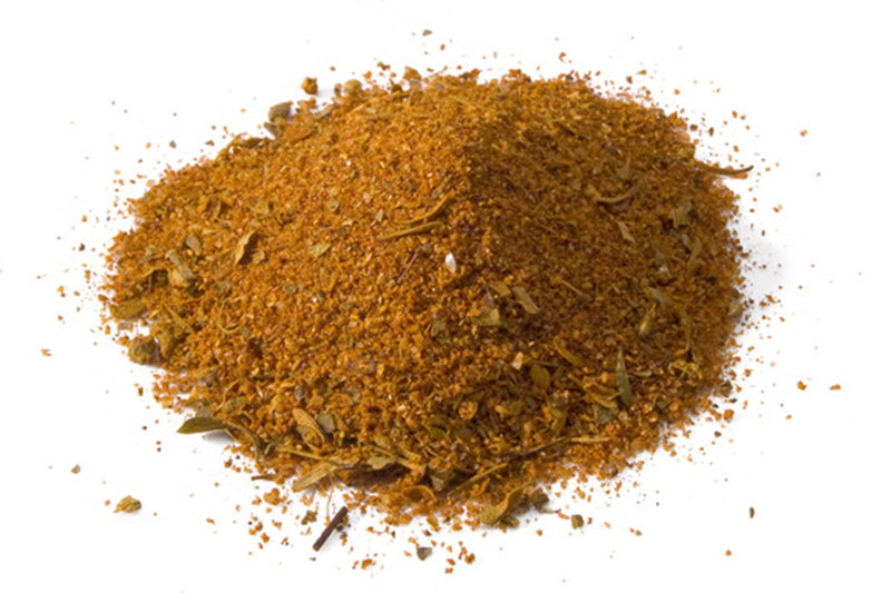 A closeup image of a pile of Cajun spice in white background.