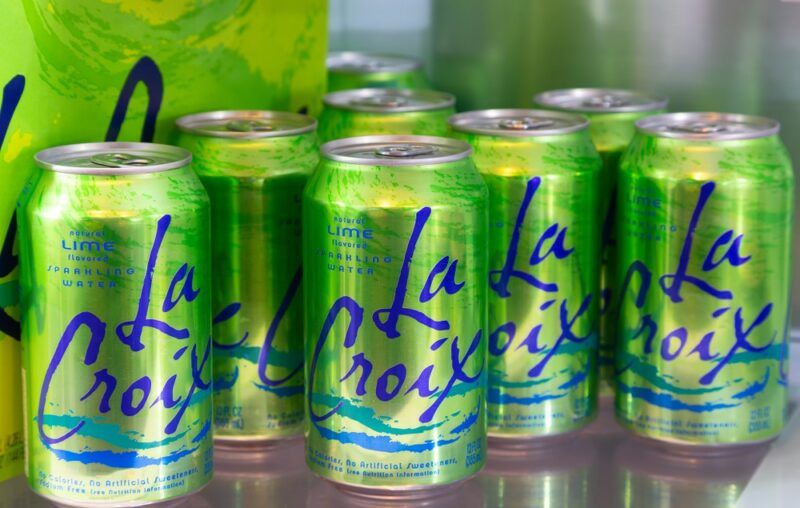 A selection of green cans of LaCroix water, with a LaCroix box in the background