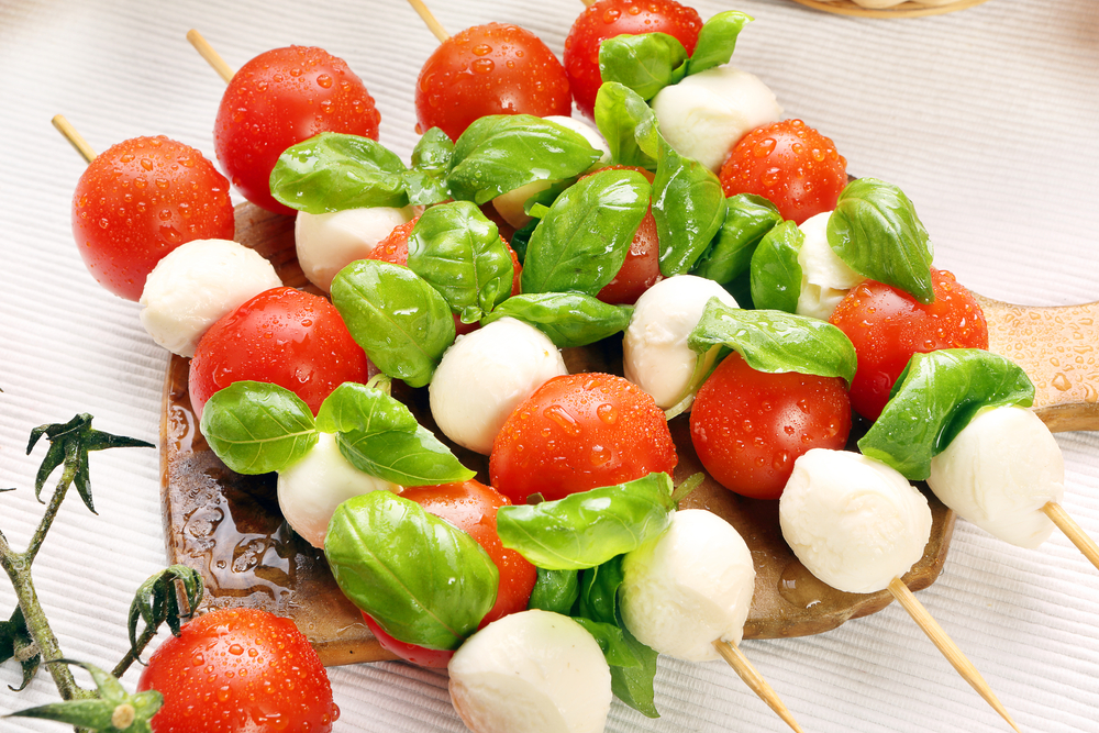 Long skewers with caprese salad ingredients threaded onto them