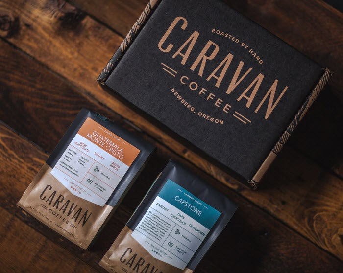 A black Caravan coffee box with two bags of coffee