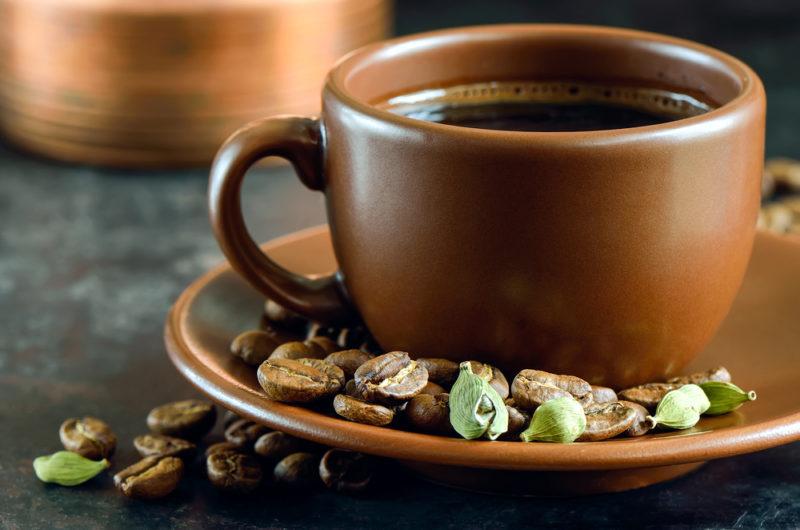 A mug of black coffee with cardamom