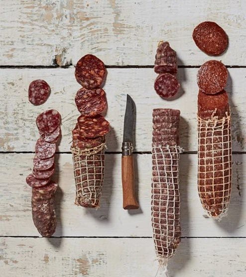 A selection of salamis that have been partially sliced