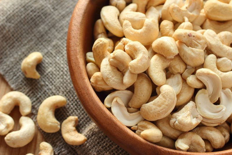 A brown bowl containing cashews