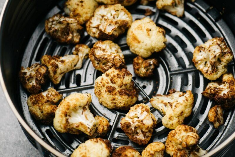 Cauliflower being cooked on the element of an air fryer