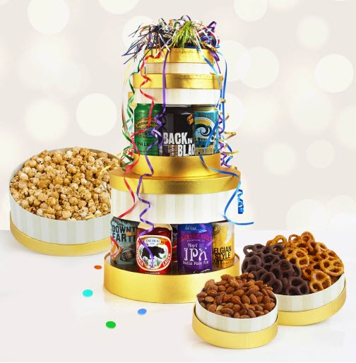 A stack of golden and white boxes with beer cans between them. Open boxes next to the stack show popcorn, pretzels and almonds.