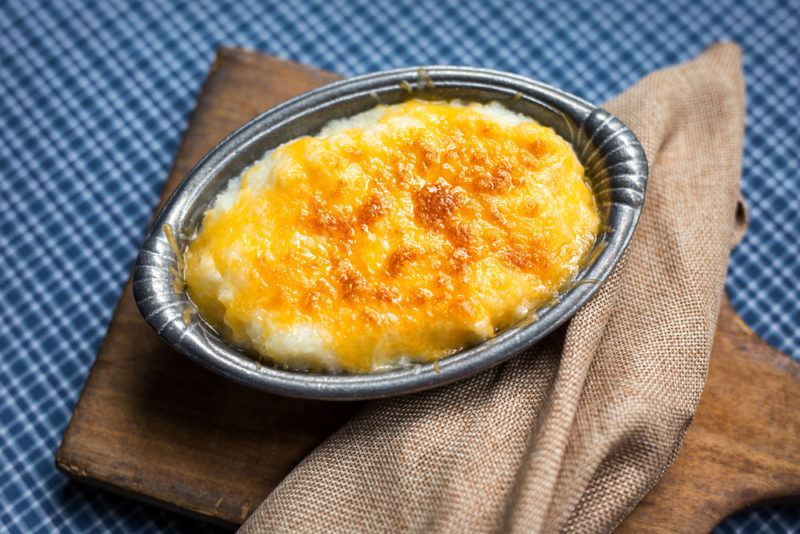 A cheese grits casserole in a pewter dish