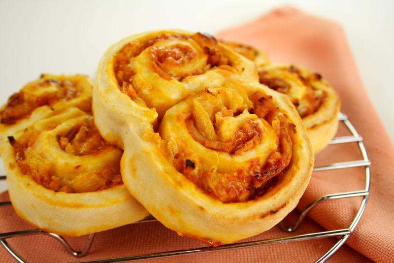 Cheese and ham scrolls on a metal cooling rack