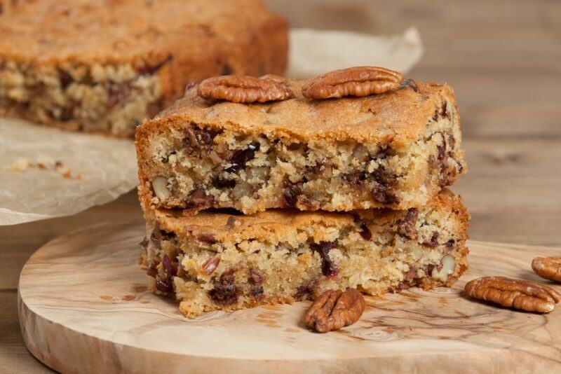 Two cheesecake cookie bars on a wooden board