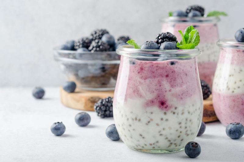 A glass jar with chia pudding, yogurt and berries