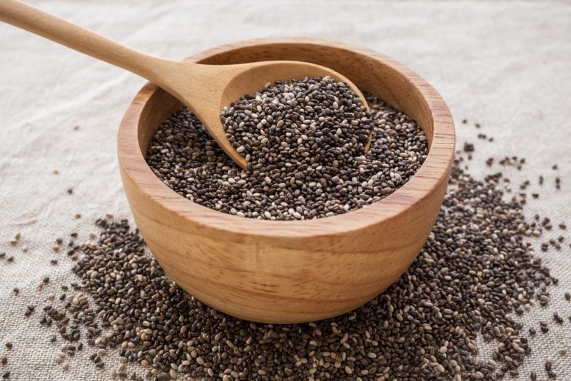 A brown bowl with a spoon of chia seeds