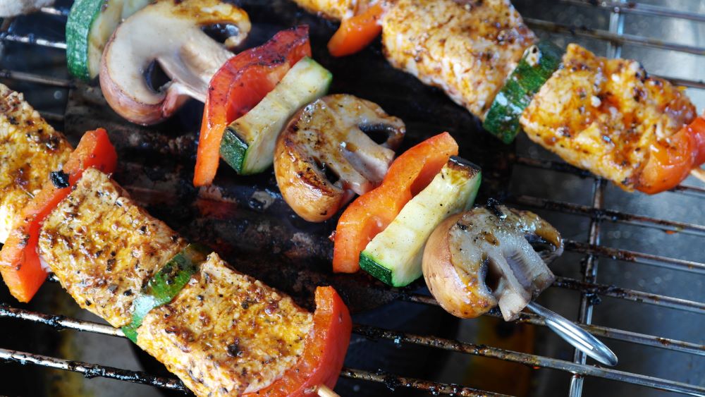 Chicken and Vegetable kabobs on a grill with a dry rub