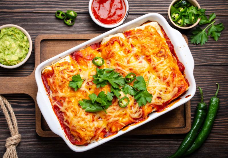 A white dish of chicken enchiladas