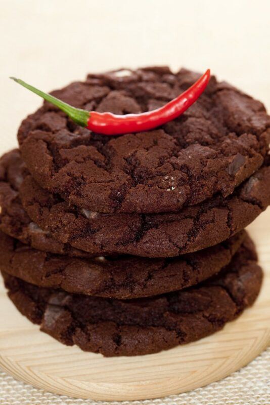 A stack of chocolate cookies with chili on top