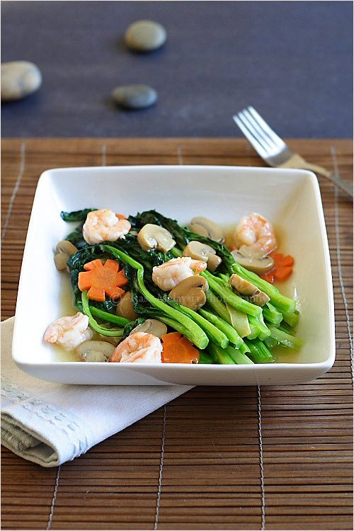 A square white dish containing stir fried Chinese vegetables