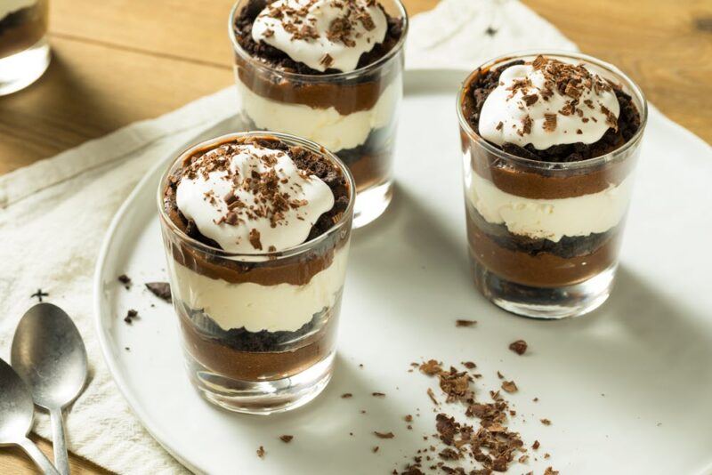 Three small glasses containing a layered chocolate mousse parfait