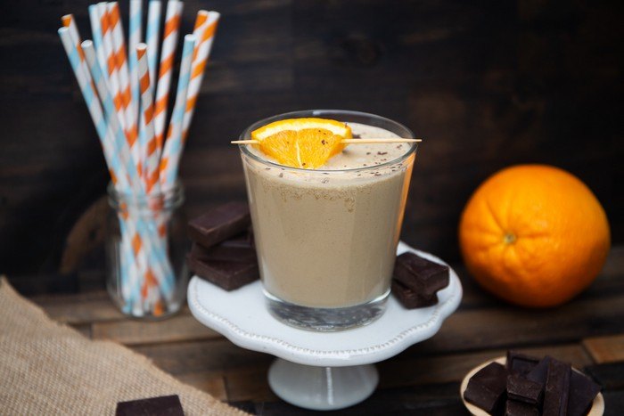 A chocolate and orange smoothie on a cake stand