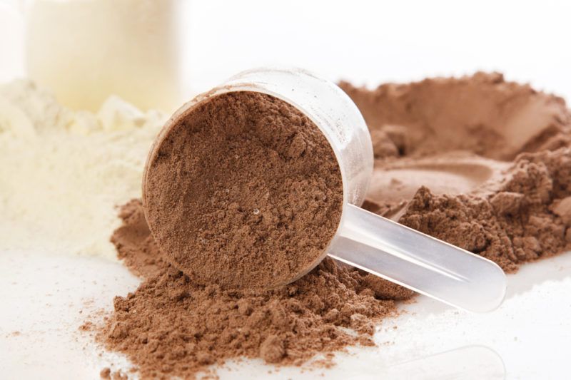 Chocolate and vanilla protein powder with scoops on a table