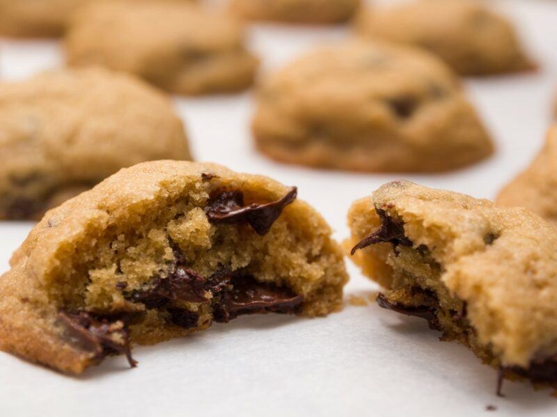 A white table with chocolate chip cookies and chips as an ingredient