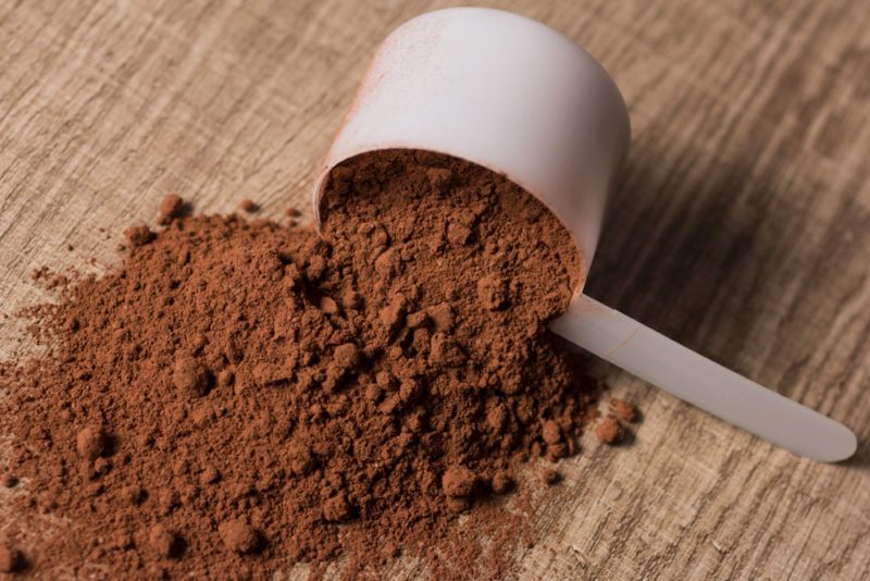 Chocolate protein powder with a scoop