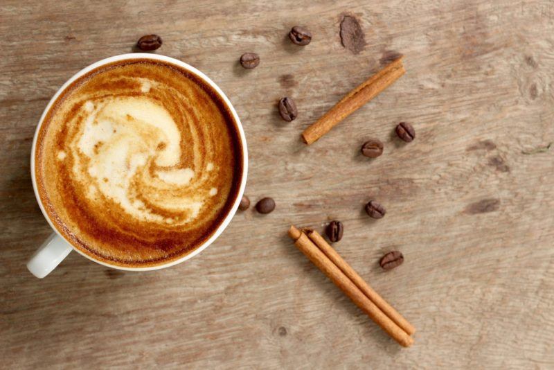 Coffee on a table with coffee beans and cinnamon