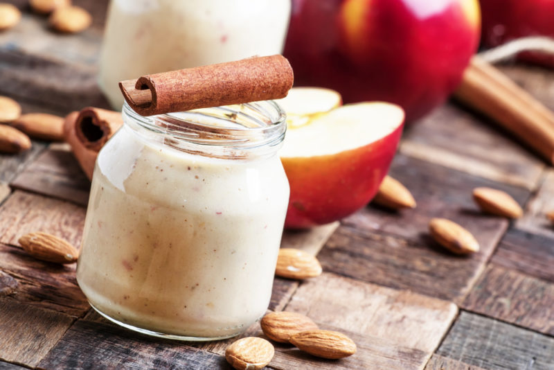 Two pots of yogurt with cinnamon mixed through