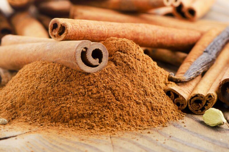 Some sticks of cinnamon on top of a pile of cinnamon