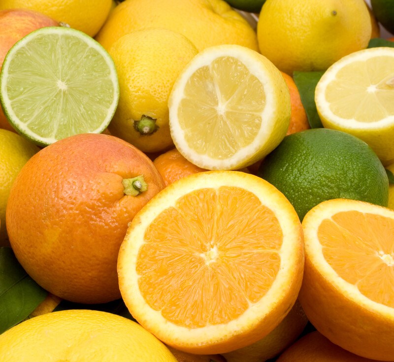 This photo shows several whole and halved citrus fruits, including grapefruit, oranges, limes, and lemons.