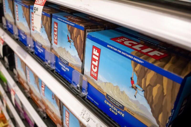 A grocery store shelf with various boxes of Clif bars