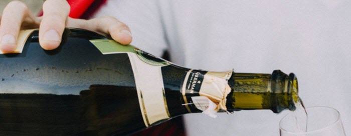 A hand pouring a bottle of wine