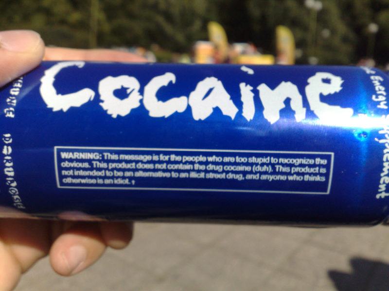 Someone holding a blue Cocaine energy drink, showing the warning label