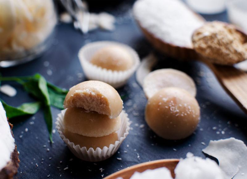 A small selection of coconut fat bombs on a dark table