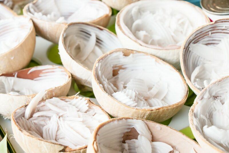 A pile of coconut halves where much of the meat has been removed